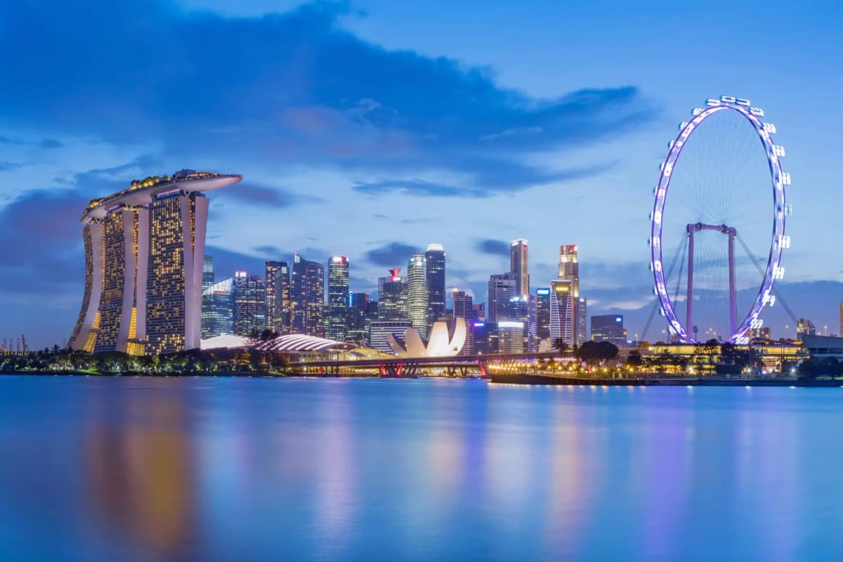 Marina Bay Sands, the Singapore Flyer and the city skyline reflected in Marina Bay at dusk