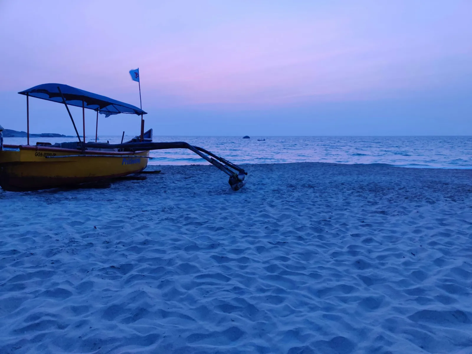 Traditional outrigger fishing boat resting on the sand at Agonda in South Goa