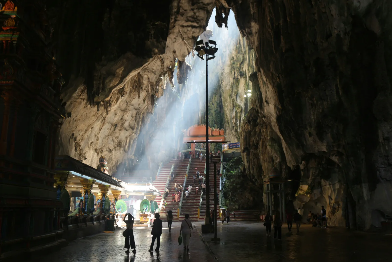 Daylight streaming through the roof opening into Temple Cave above the shrine at Batu Caves