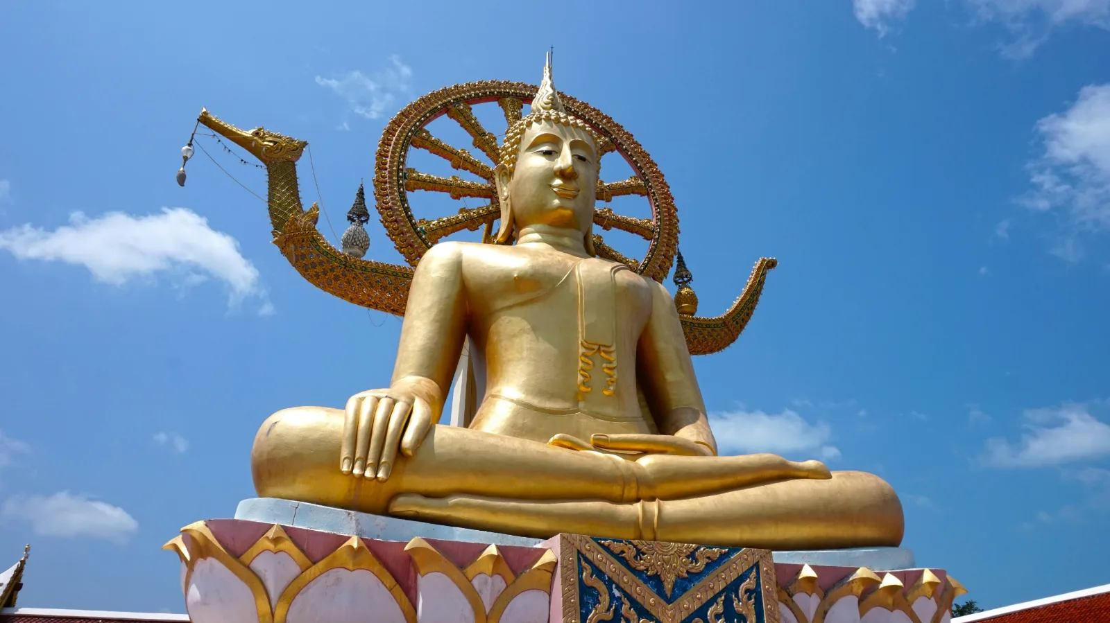 Golden Big Buddha statue at Wat Phra Yai on Koh Samui under a blue sky