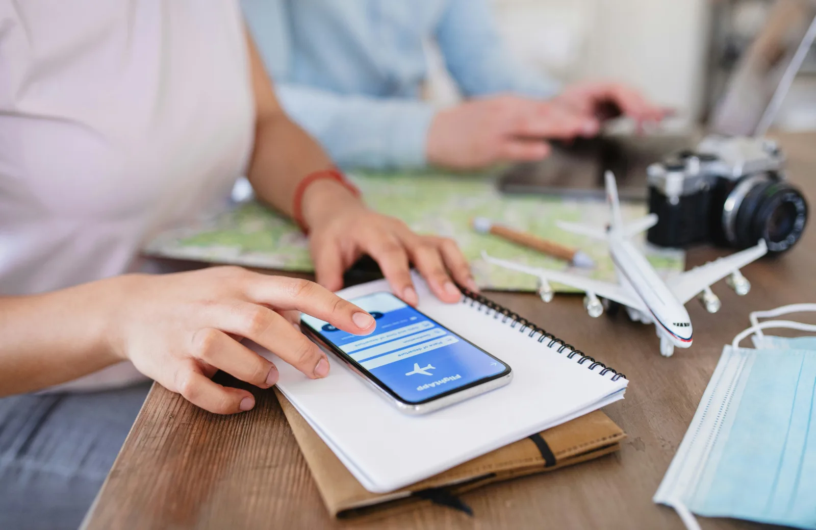 Traveller planning and booking a trip on a laptop with a passport and notes