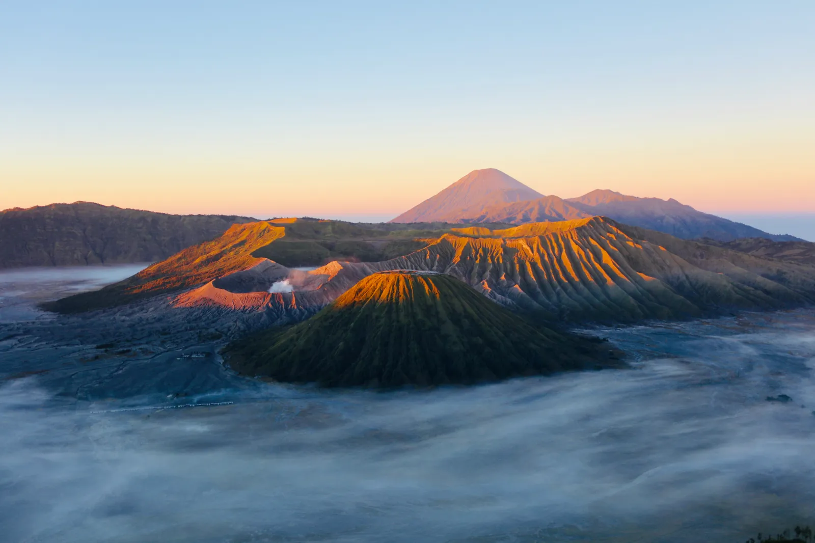 Morning mist filling the Bromo caldera at sunrise, seen from a viewpoint on the crater rim