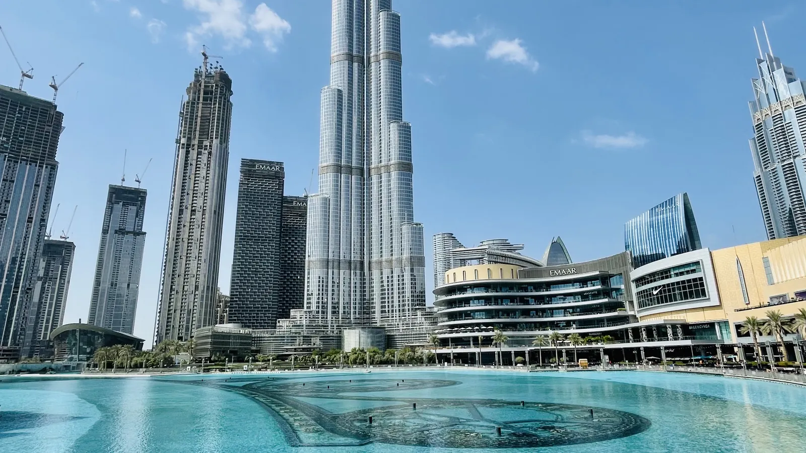 Burj Khalifa rising above Downtown Dubai and Burj Lake on a clear blue day