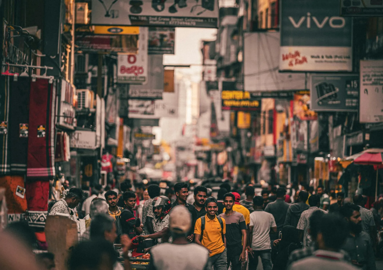 Crowded shopping street lined with shop signs and handcarts in central Colombo, Sri Lanka