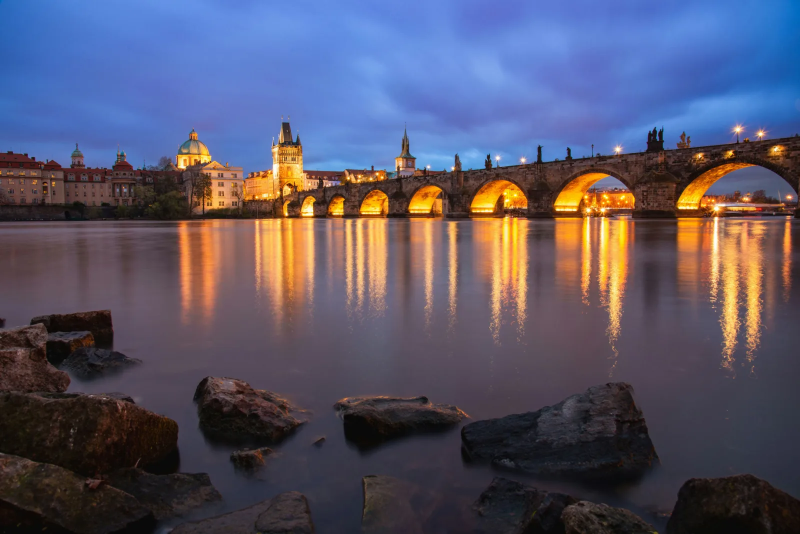 Charles Bridge and the Vltava River in Prague lit up in the evening
