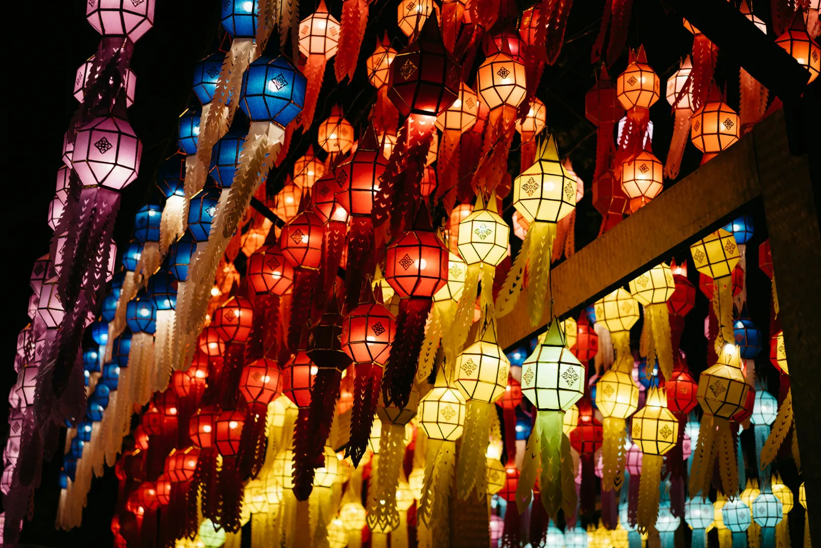 Colourful Lanna style paper lanterns hanging in long rows during the festival season in Chiang Mai