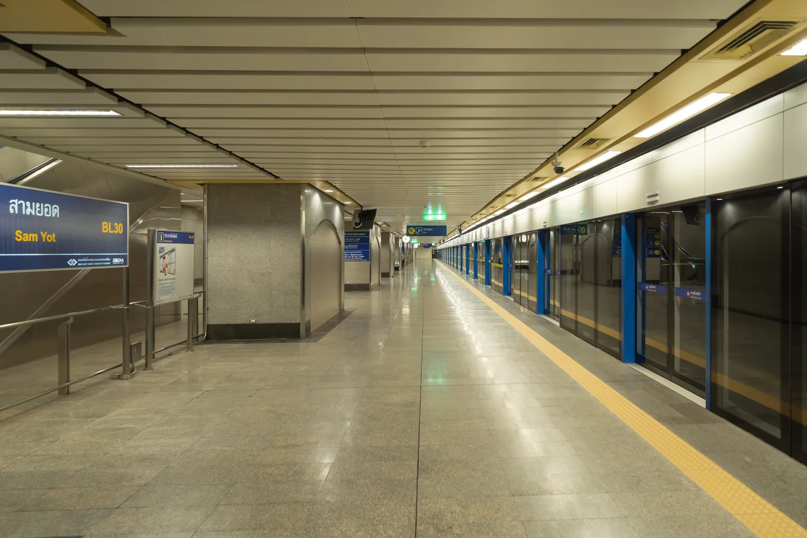 Clean, well lit metro platform with platform screen doors and an arriving train