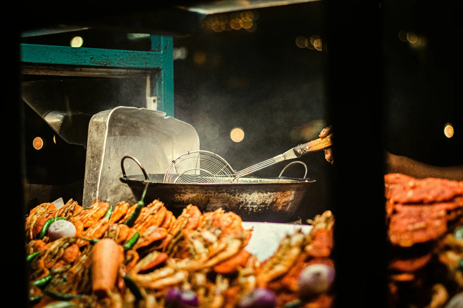 Street food cook preparing a sizzling spread on a hot griddle at a Colombo stall