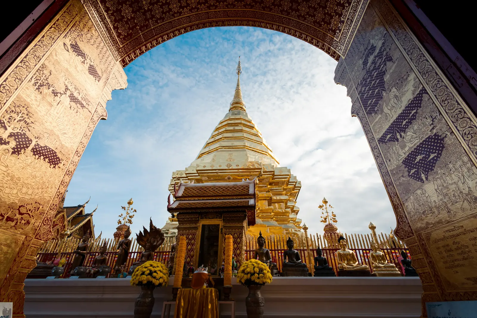 Golden chedi of Wat Phra That Doi Suthep framed by a temple archway in Chiang Mai