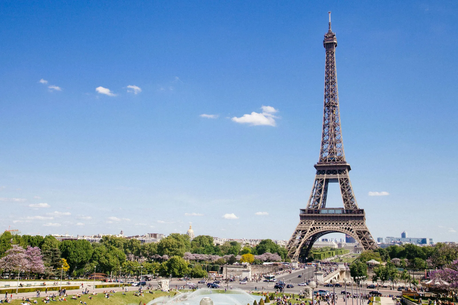Eiffel Tower in Paris standing above green trees on a bright clear day