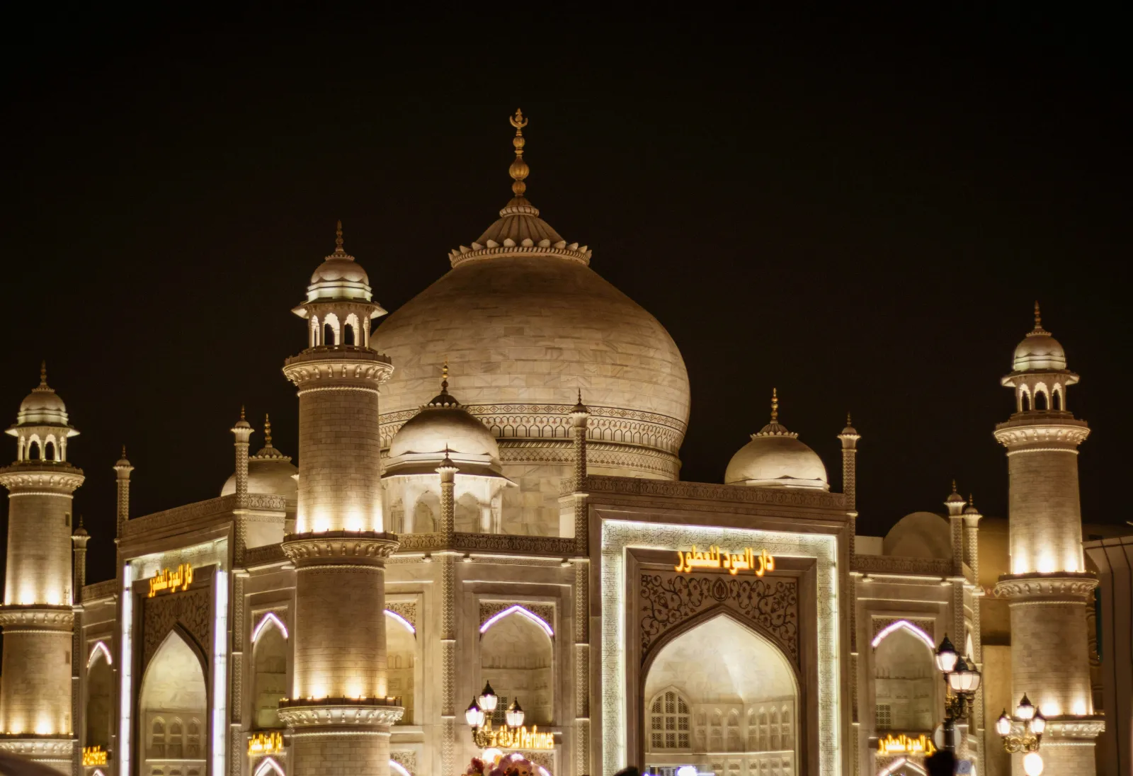 Domed pavilion with minarets lit in warm gold lights at Global Village Dubai