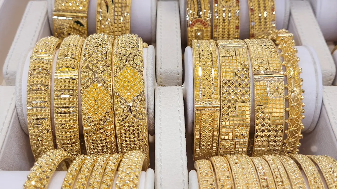 Rows of ornate gold bangles on display in a Dubai gold market jewellery shop