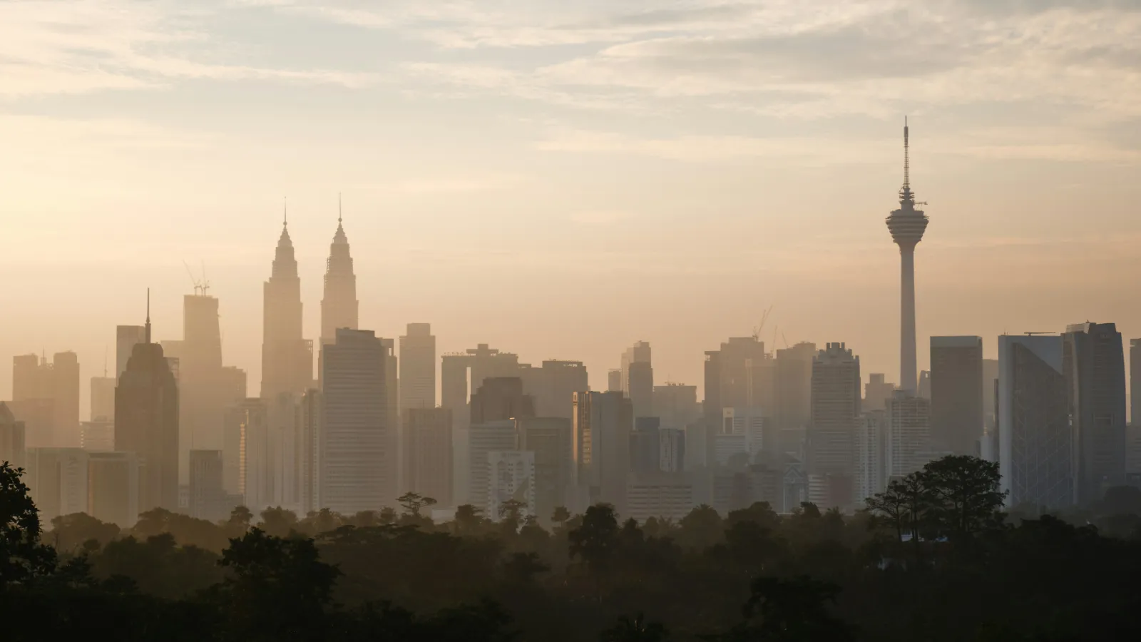 Kuala Lumpur skyline with the Petronas Twin Towers and KL Tower rising above morning haze