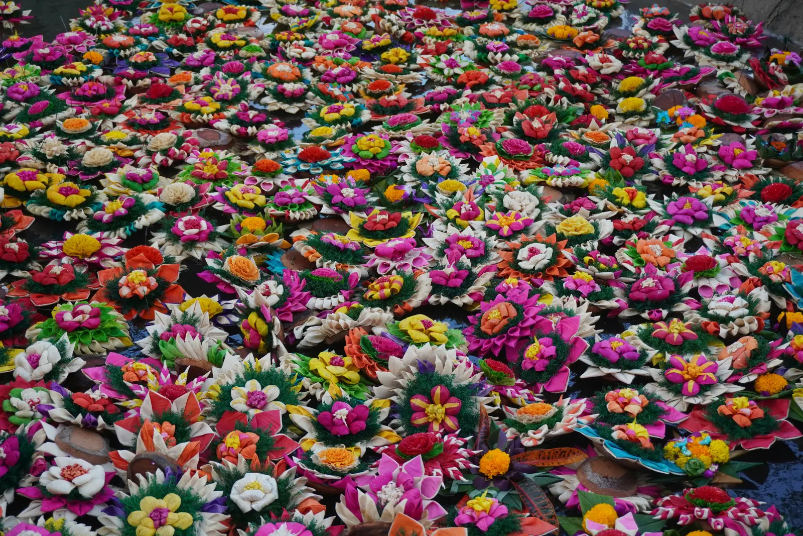 Rows of handmade krathong floats with marigolds and orchids ready for Loy Krathong in Chiang Mai