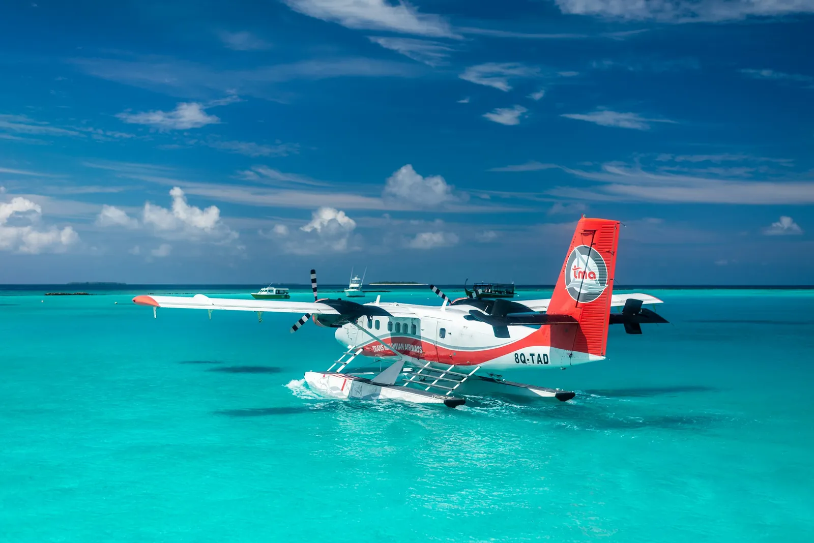 Seaplane landing on a turquoise lagoon in the Maldives on a clear sunny day