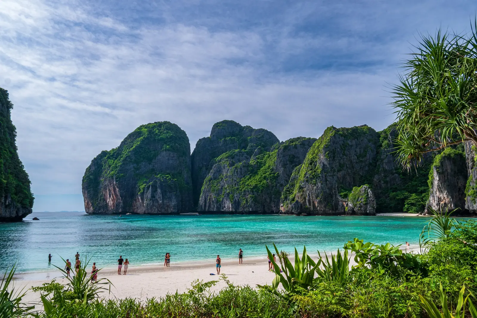 Visitors on the white sand of Maya Bay framed by cliffs, Koh Phi Phi Leh