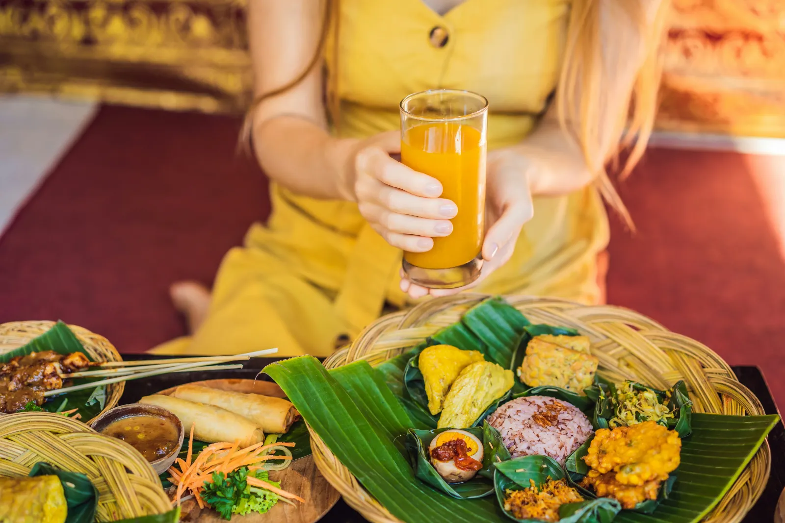 Colourful meal of rice and side dishes served on a fresh banana leaf with a cold drink