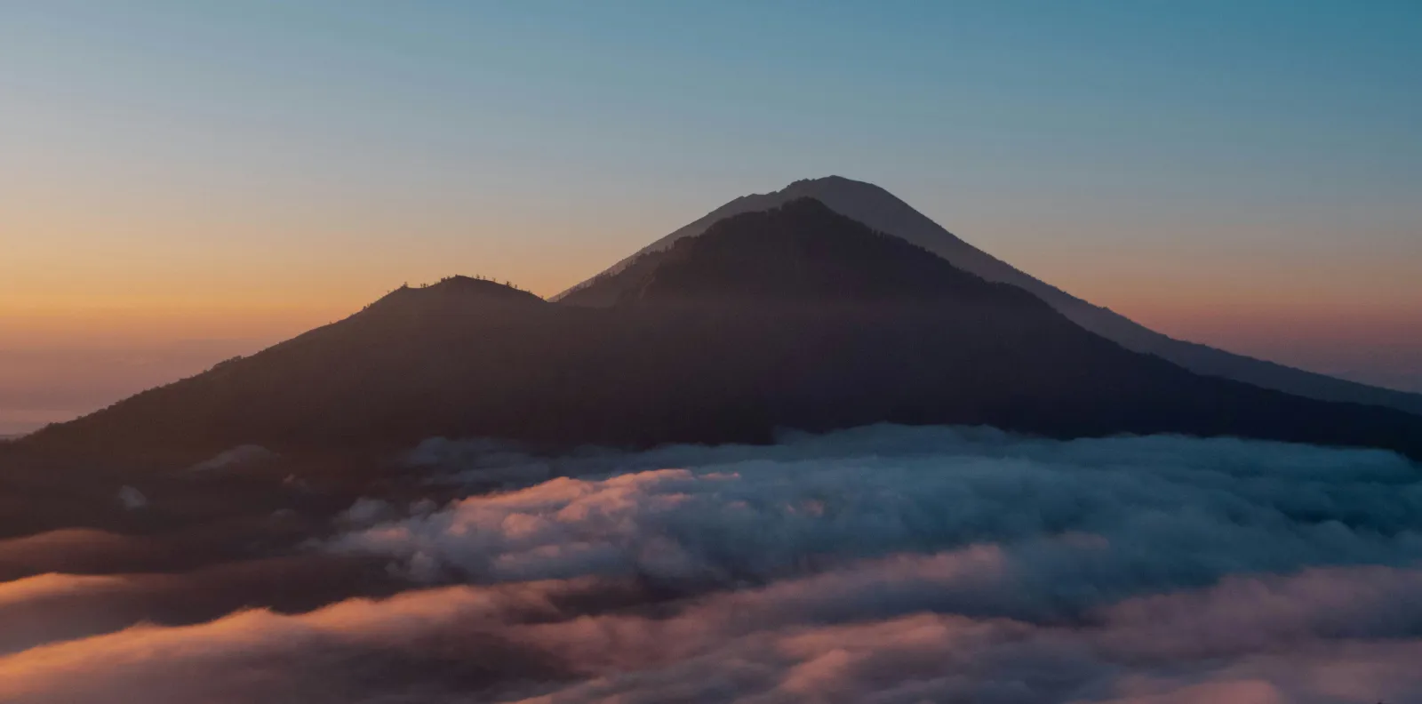 Dawn sky and a sea of clouds seen from the slopes of Mount Batur in Bali