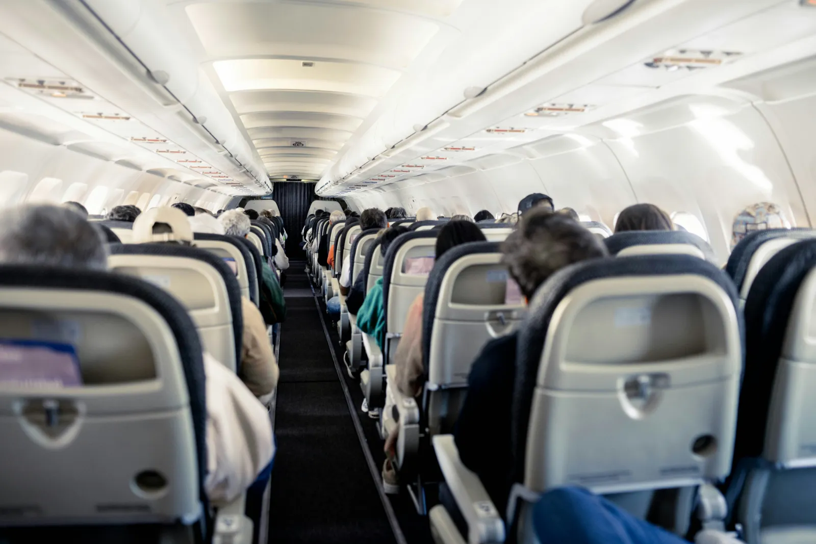 Passengers seated in the economy cabin of a narrow body jet before departure