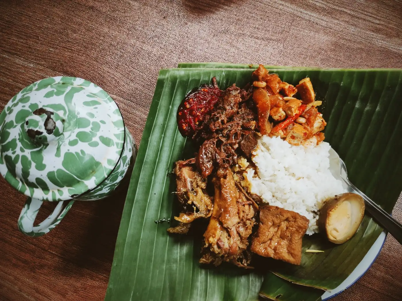 Indonesian rice plate with tempeh, egg, meat and sambal served on a banana leaf