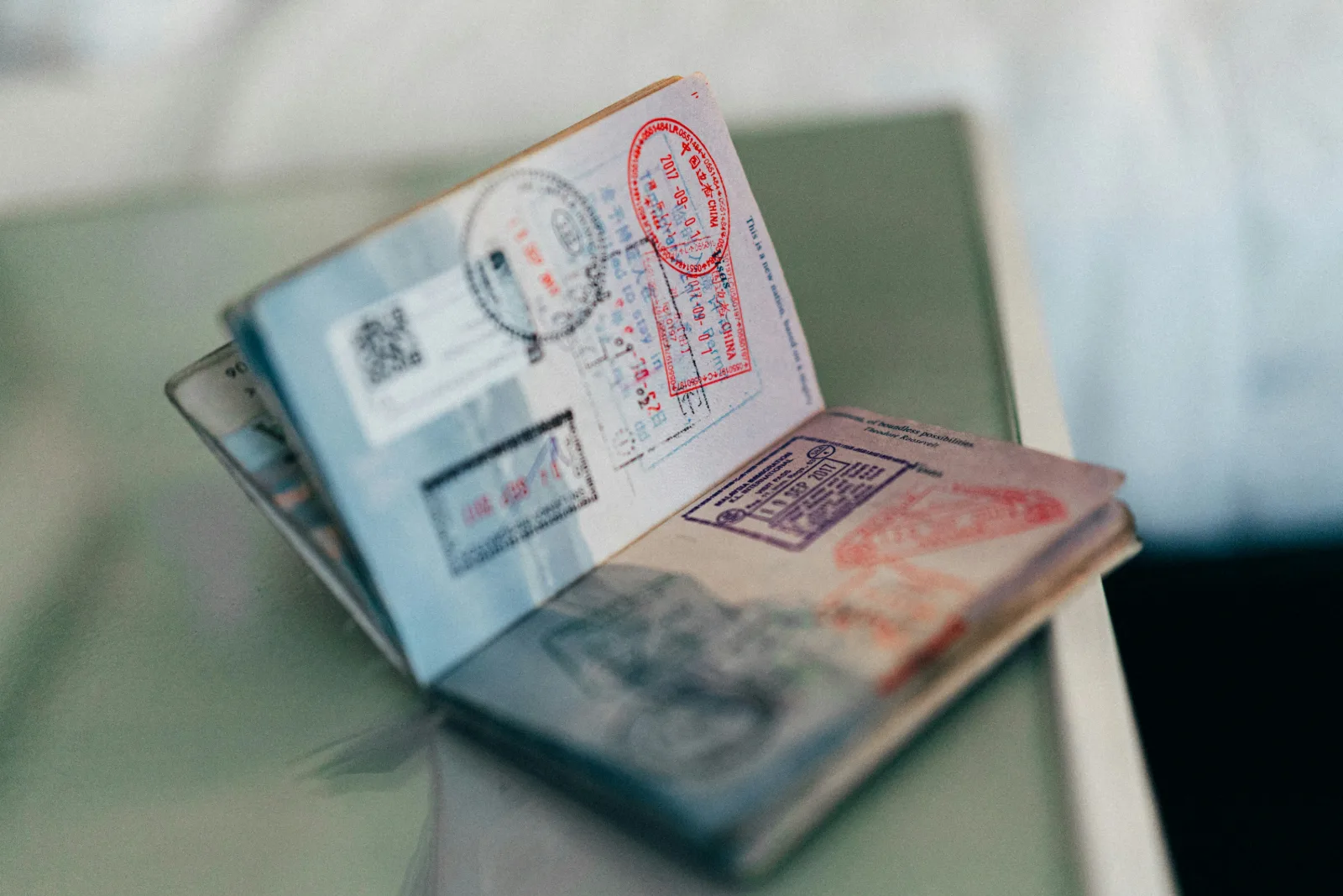 Open passport pages filled with entry and exit stamps from earlier international trips
