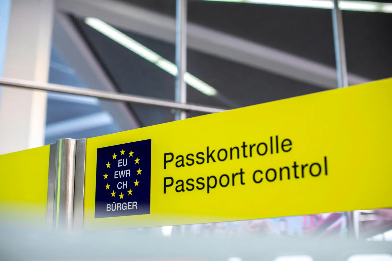 Yellow passport control sign above the immigration area at an international airport