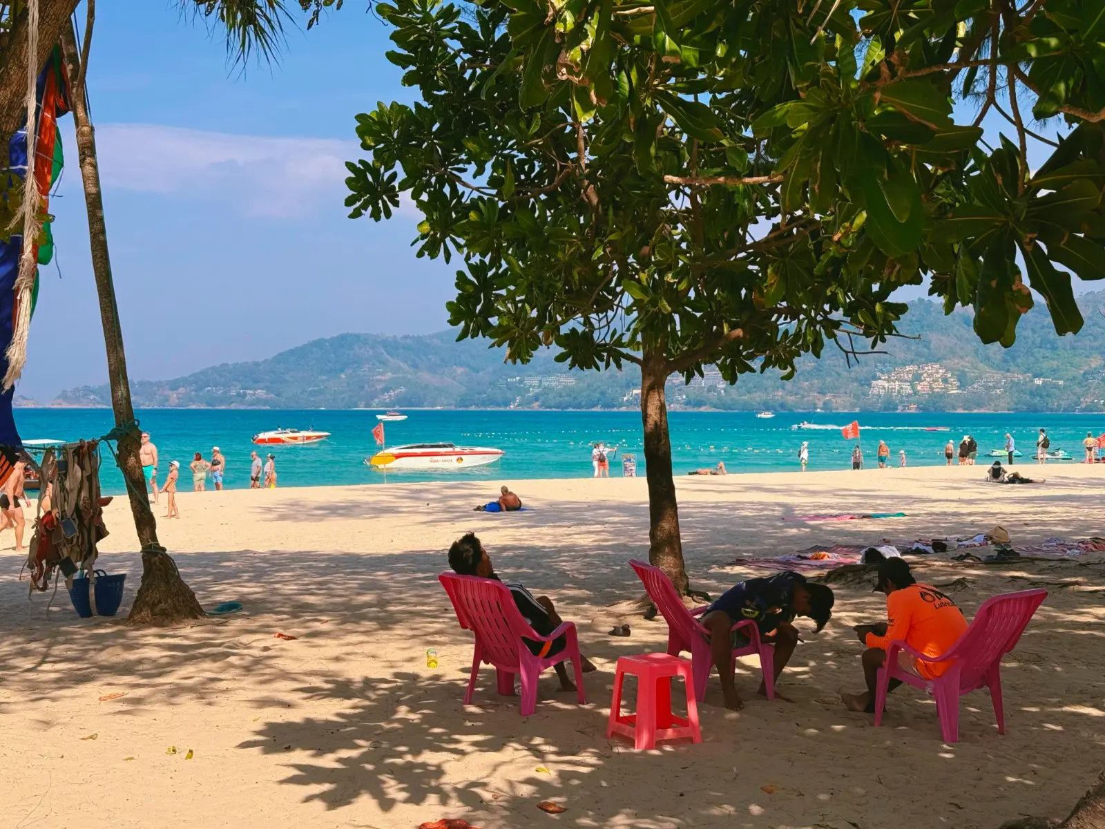 Shaded sand and calm blue water at Patong Beach in Phuket on a dry season day