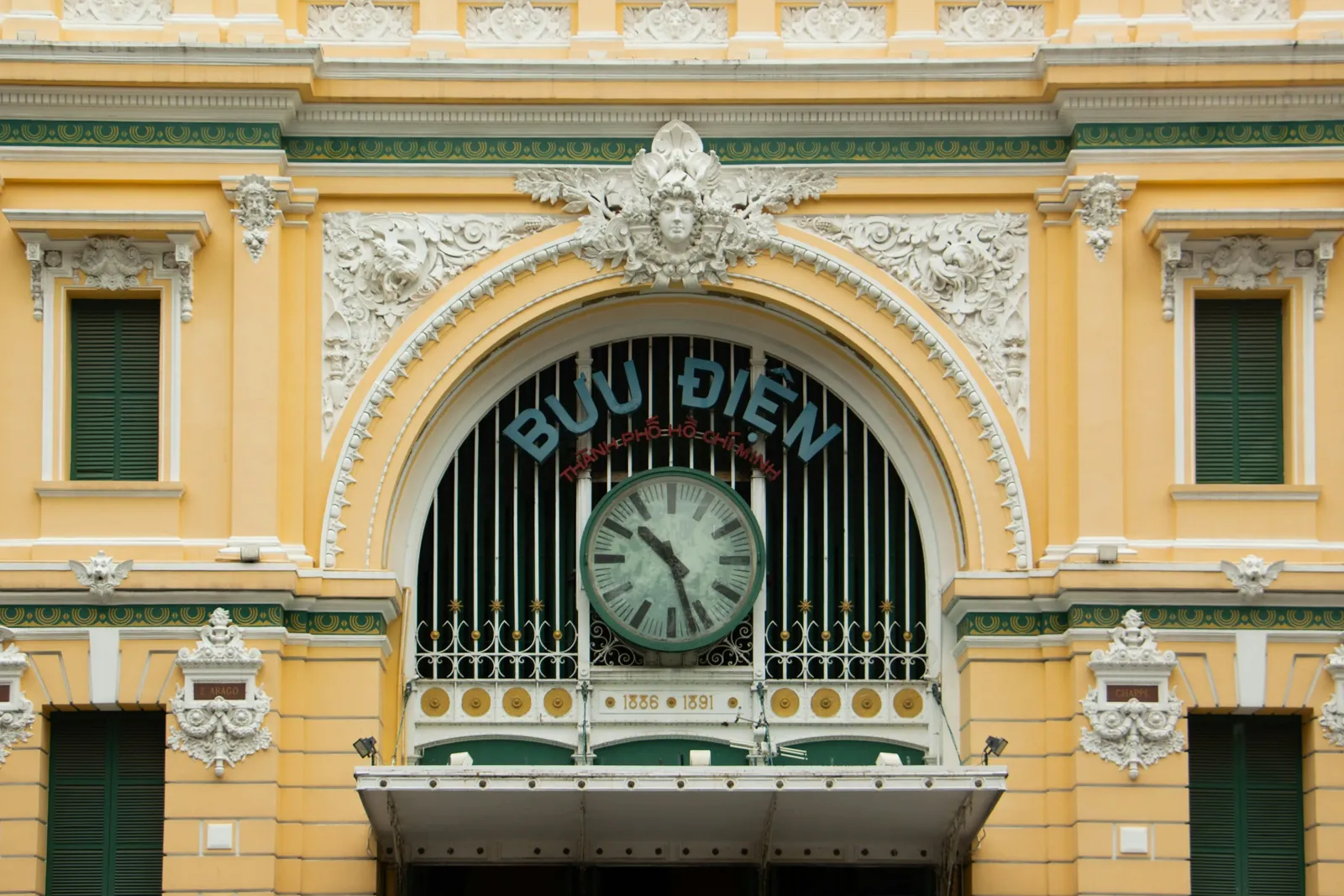 Yellow colonial facade and clock of Saigon Central Post Office in Ho Chi Minh City