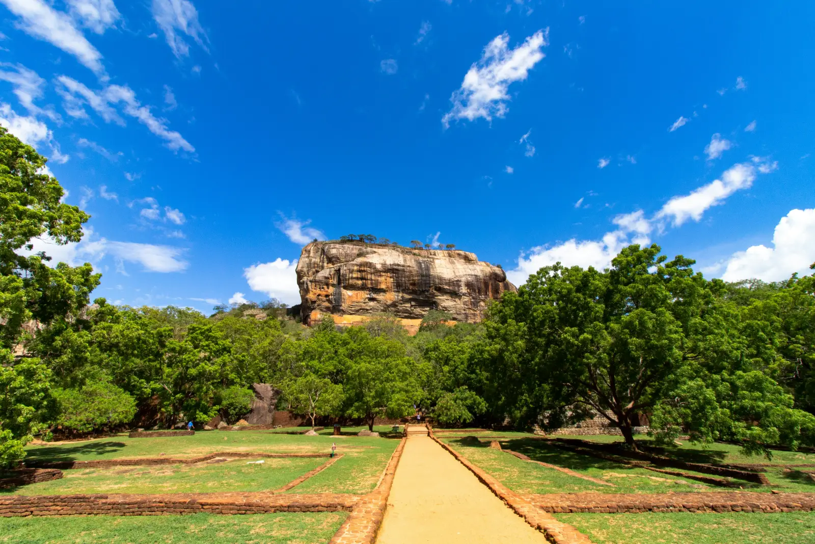 Sigiriya Rock Fortress rising above green forest in central Sri Lanka on a clear day