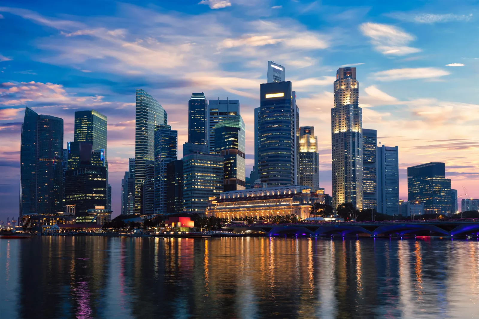 Modern Singapore skyline and Marina Bay waterfront glowing in the evening light