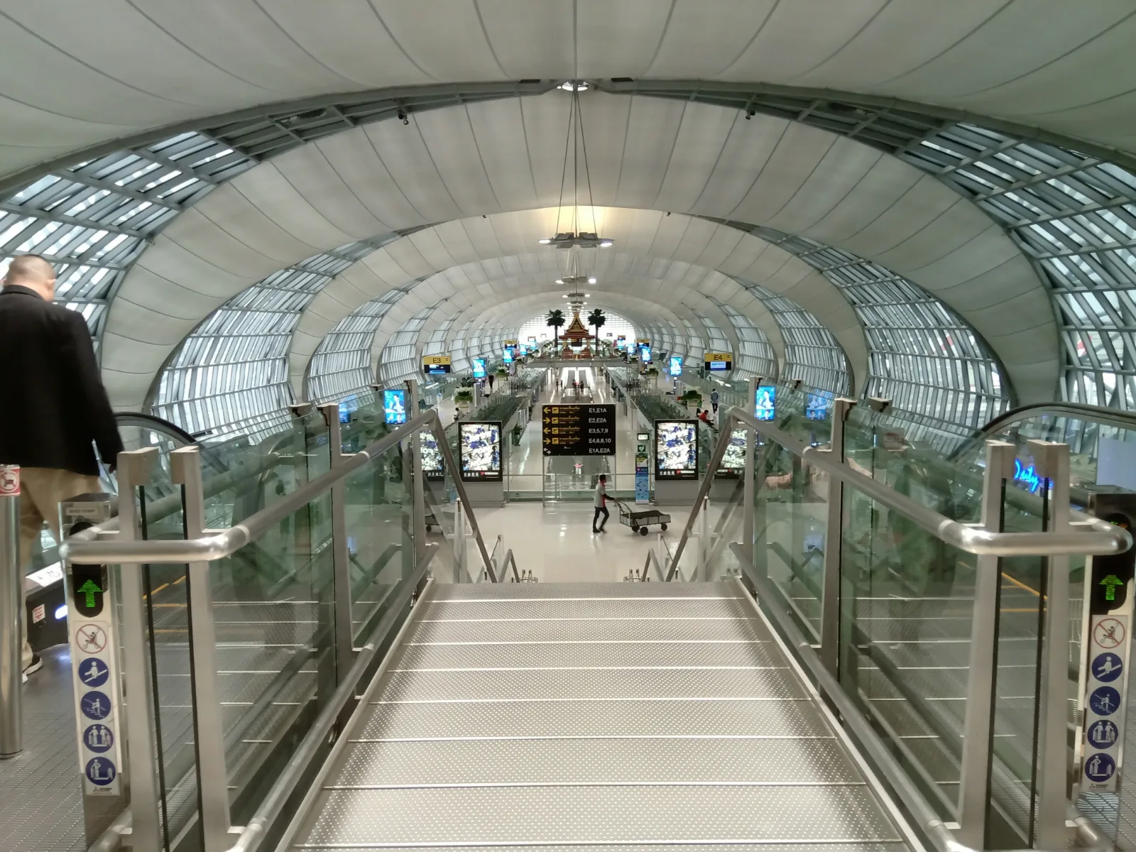 Travellers inside the bright terminal concourse of Suvarnabhumi Airport in Bangkok