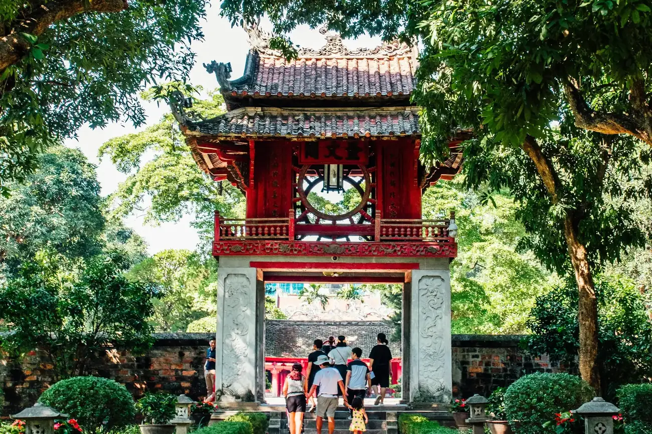Visitors walking along the stone path to a gate inside the Temple of Literature, Hanoi