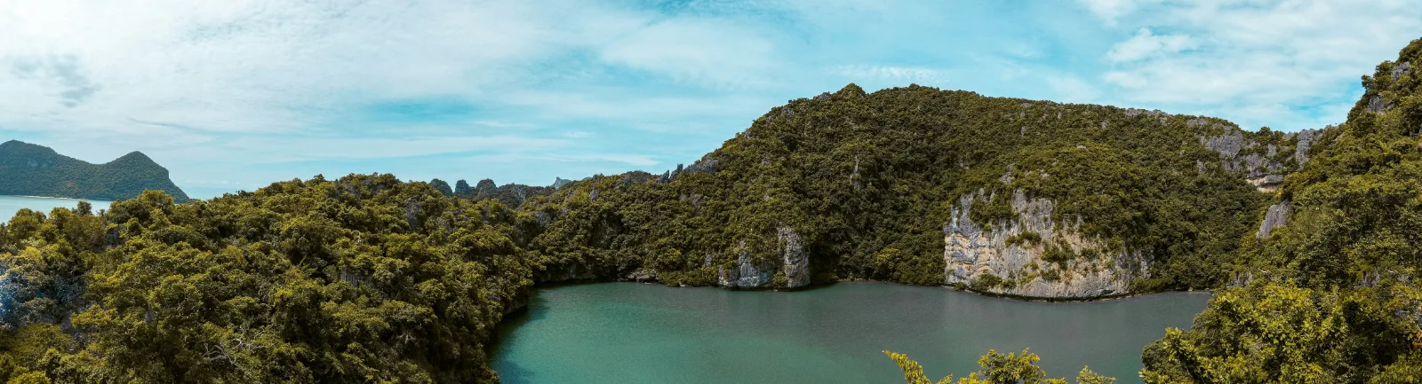 Emerald saltwater lake surrounded by jungle cliffs inside Ang Thong National Marine Park
