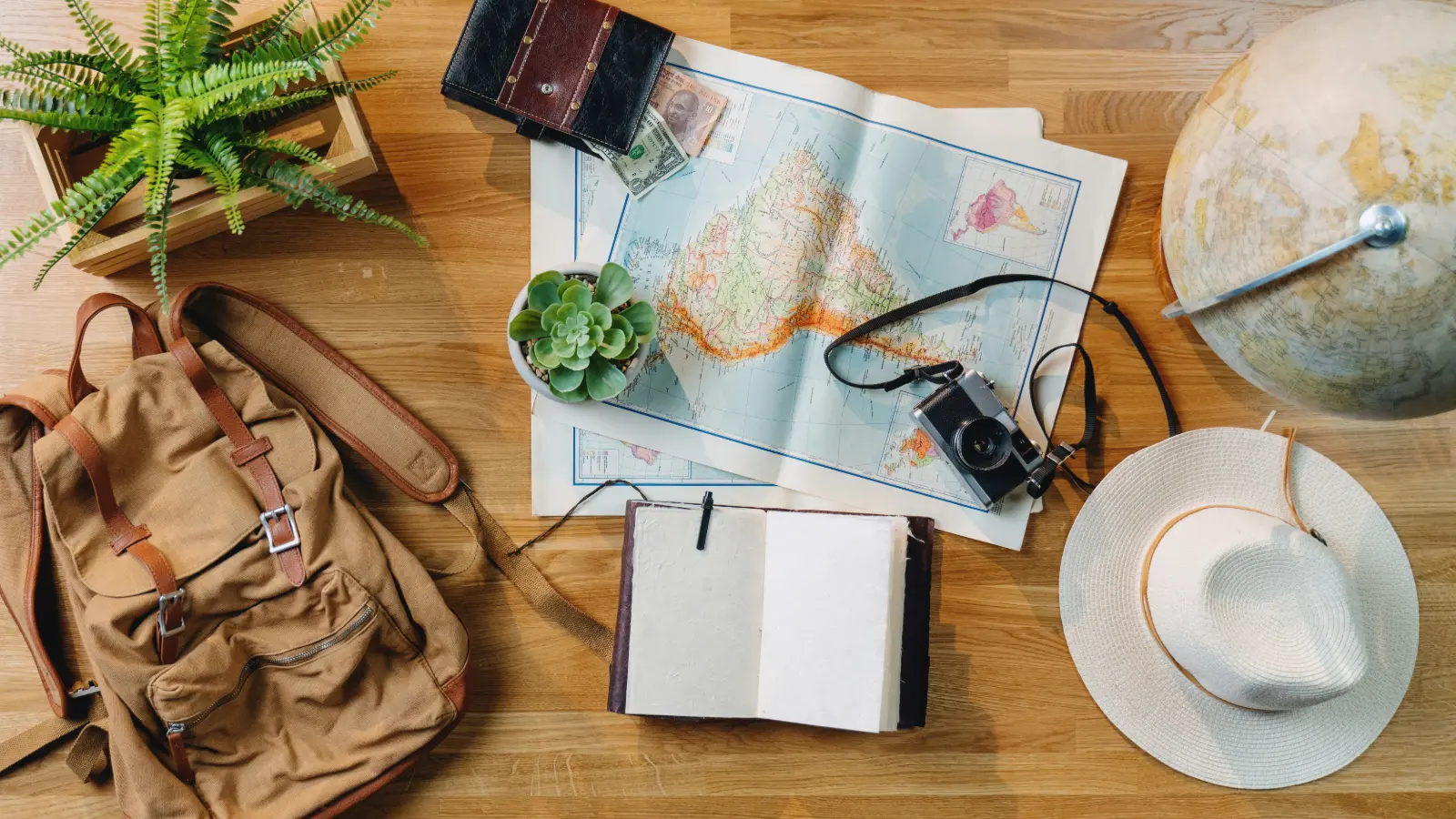 Travel plan notebook, map and coffee on a desk while checking trip details