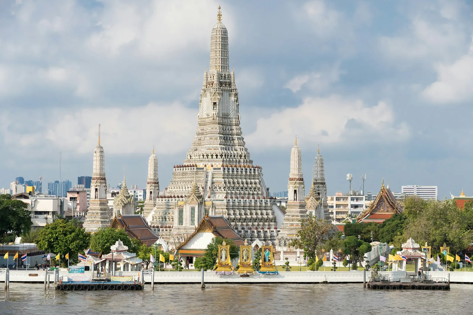 Wat Arun temple rising above the Chao Phraya River in Bangkok on a bright day