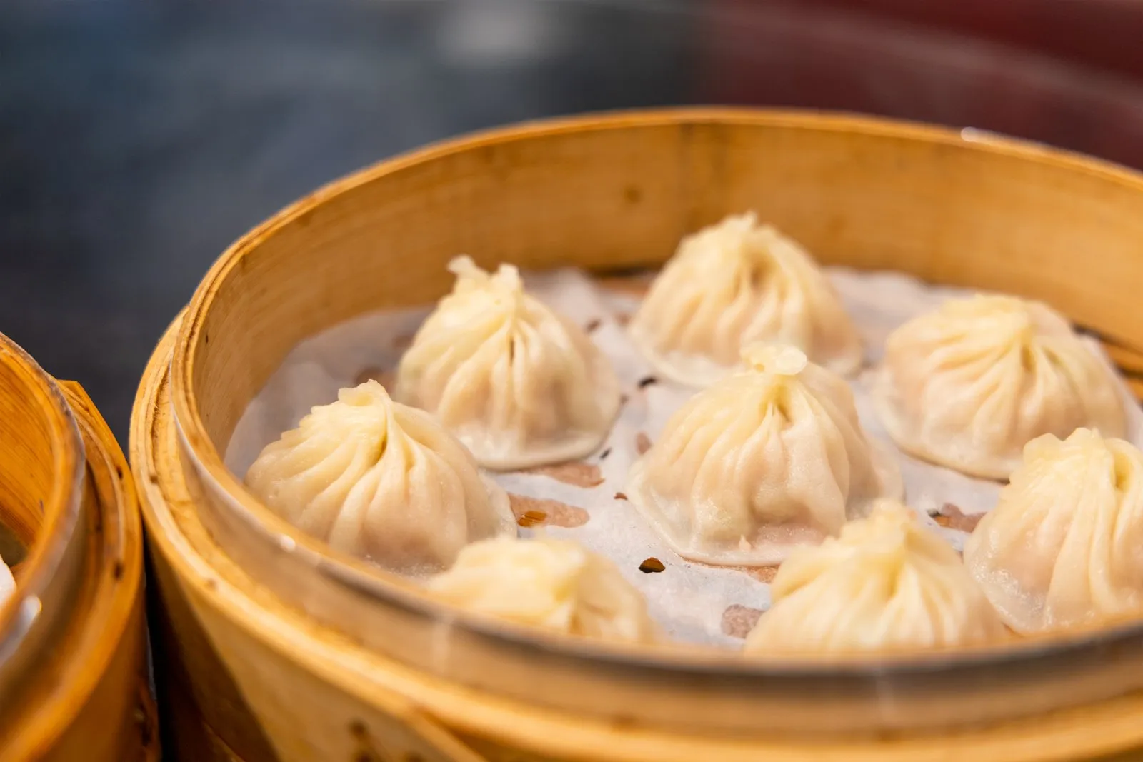 Xiaolongbao soup dumplings arranged in a bamboo steamer, a classic Shanghai dish