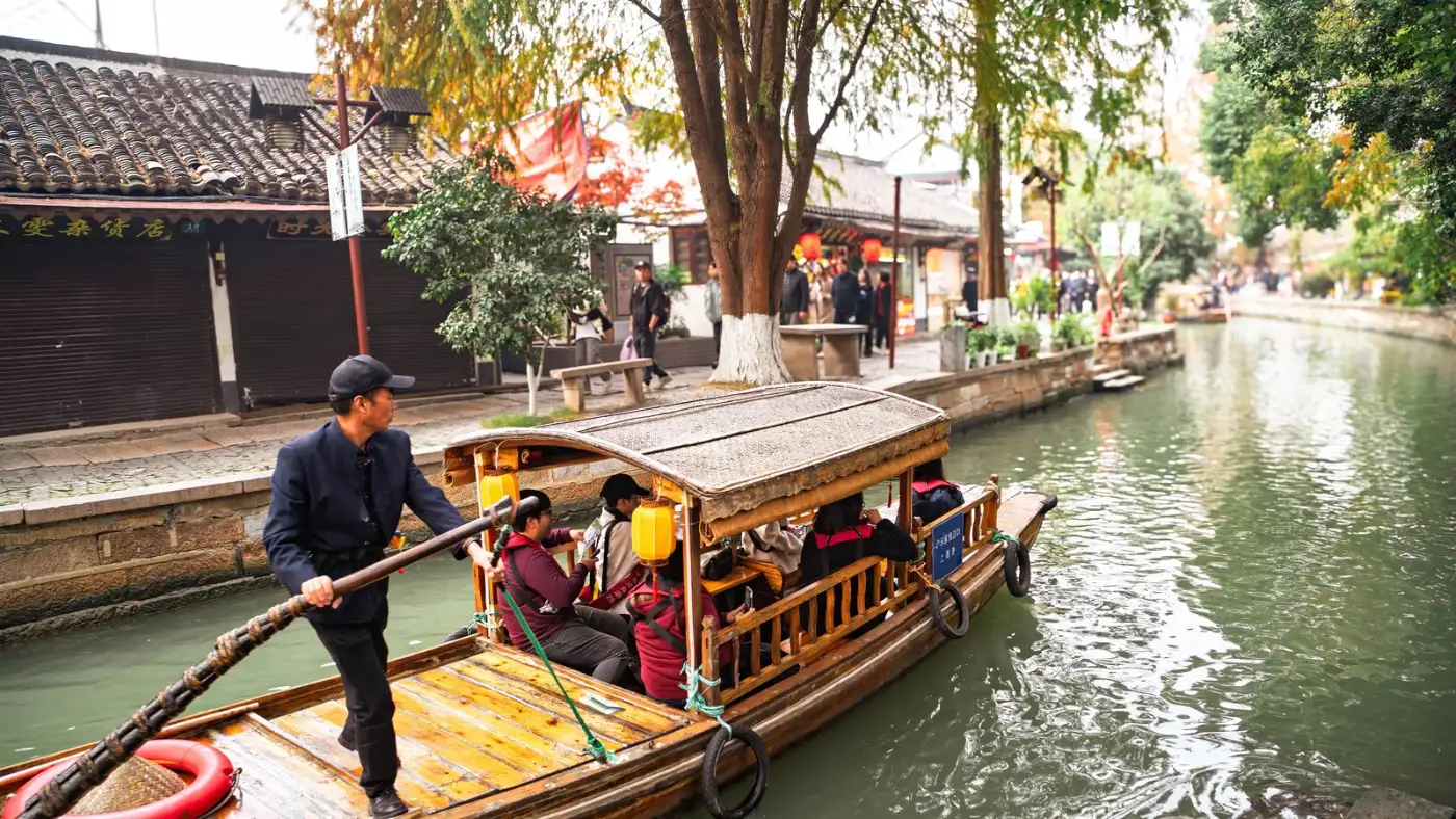 Boatman rowing visitors along a canal lined with old houses in Zhujiajiao water town near Shanghai