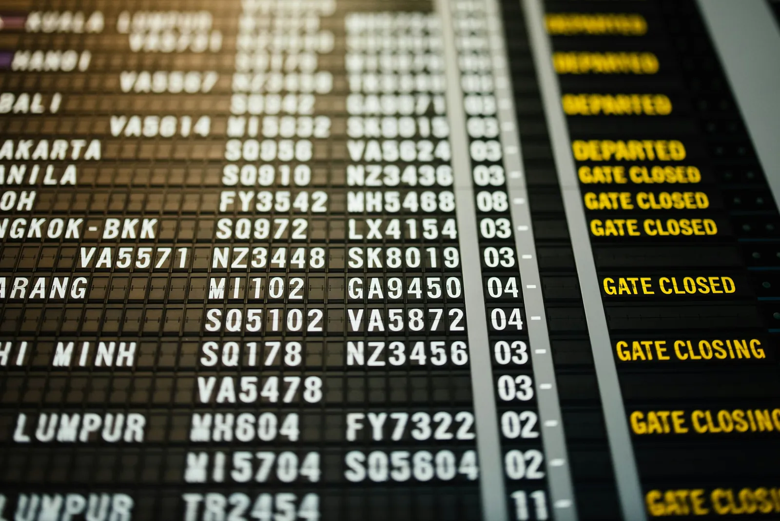 Airport departure board listing flights to Kuala Lumpur, Jakarta and other Asian hub cities